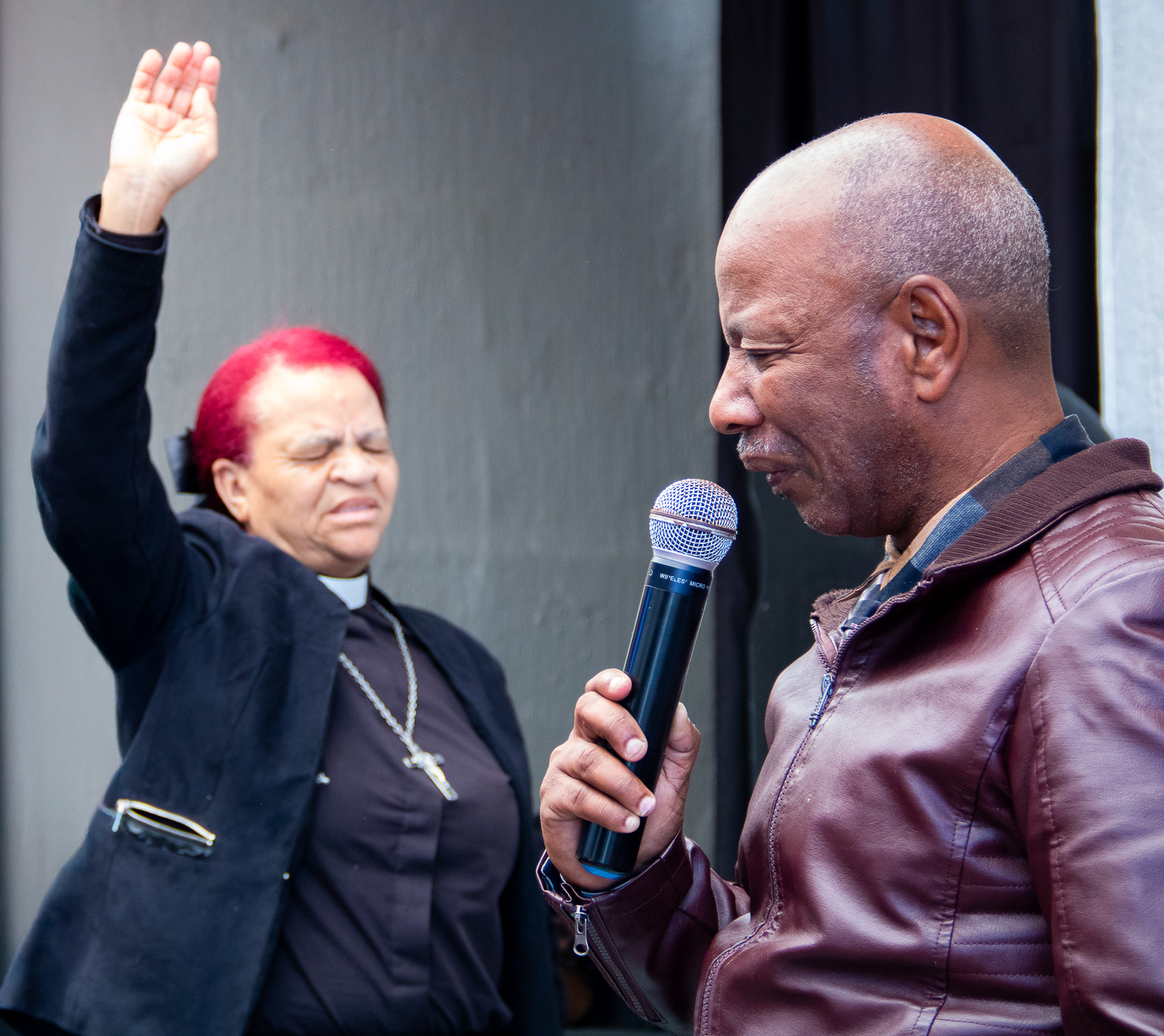 Pastor L. van Rooyen praying with a member during a service